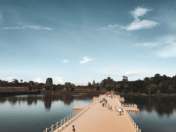 People on lake against sky