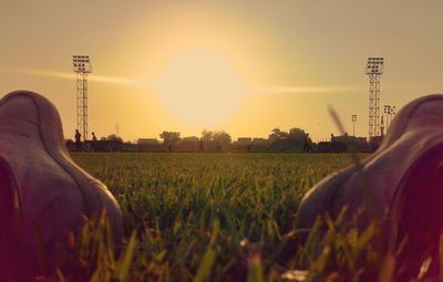 Close-up of man in field against sky during sunset