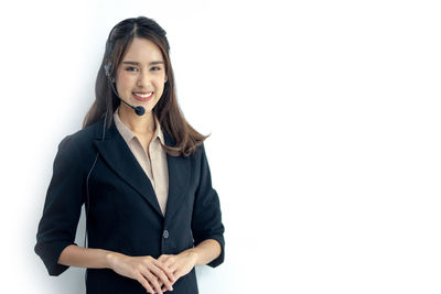 Portrait of a smiling young woman against white background