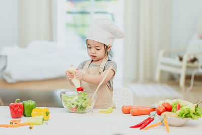 Cute girl eating food on table