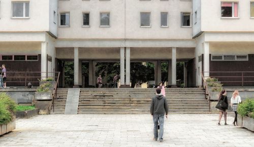 Rear view of people walking outside building