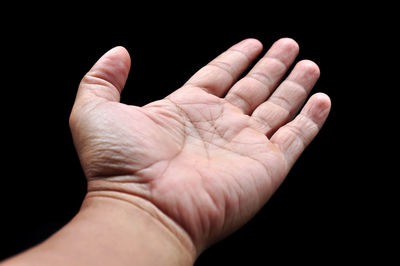 Close-up of hand against black background