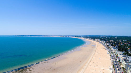 Scenic view of beach against clear blue sky