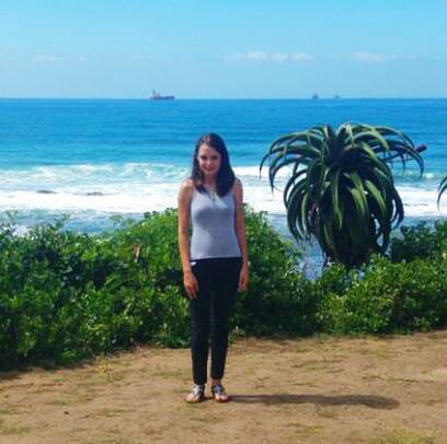 YOUNG WOMAN STANDING BY SEA