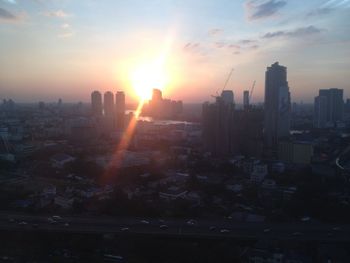 Modern buildings in city against sky during sunset