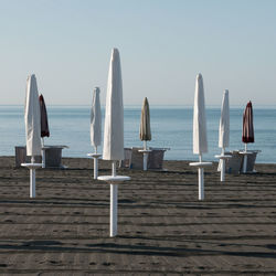 Wooden posts on beach against clear sky