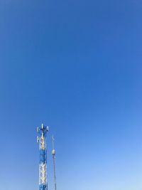 Low angle view of communications tower against clear blue sky