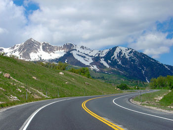 Road by mountains against sky