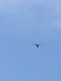 Low angle view of airplane flying against clear blue sky