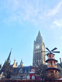 Low angle view of clock tower in city against sky