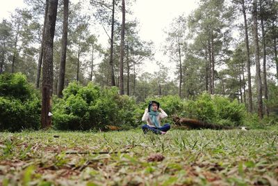 Rear view of woman standing in forest