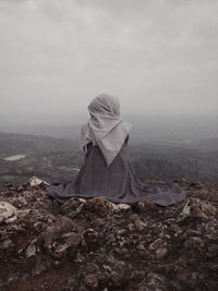 Rear view of woman on landscape against sky