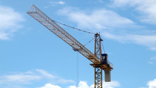 Low angle view of crane against sky