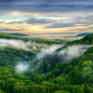 Scenic view of mountains against sky during sunset foggy 