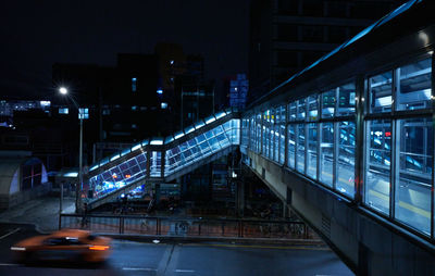 Illuminated bridge over street in city at night