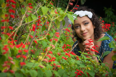 Portrait of smiling woman with red and plants