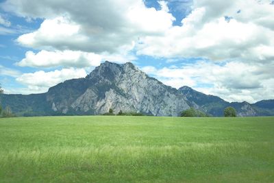 Scenic view of field and mountains against sky