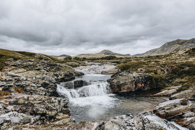 Scenic view of waterfall against sky