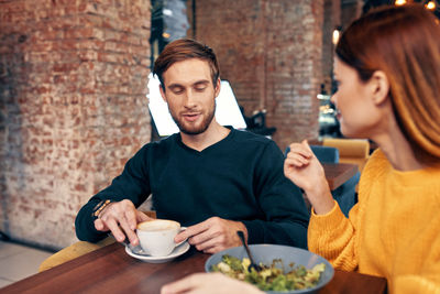 Young couple sitting on table at restaurant