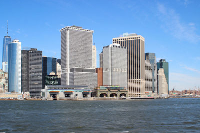 Modern buildings by sea against sky in city