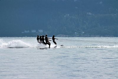 People water skiing in sea against sky