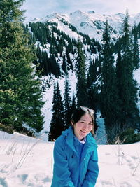 Portrait of smiling young woman on snow covered mountain