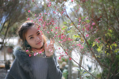 Portrait of woman standing against trees