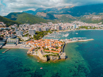 High angle view of townscape by sea against sky