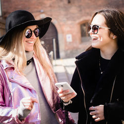 Smiling young woman wearing sunglasses in city