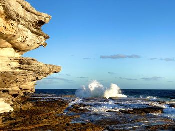 Rocks on beach against clear sky