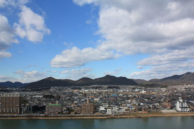 View of cityscape against cloudy sky