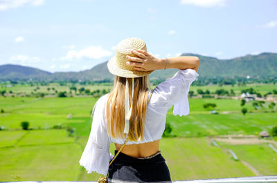 Woman wearing hat standing on field