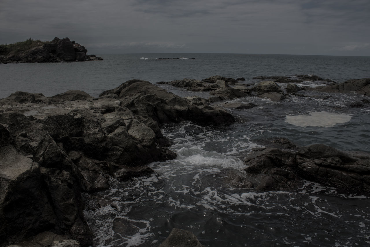 ROCKS ON BEACH AGAINST SKY