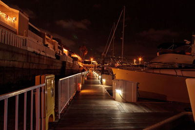 Illuminated bridge against sky at night