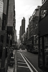 Railroad tracks by buildings in city against sky