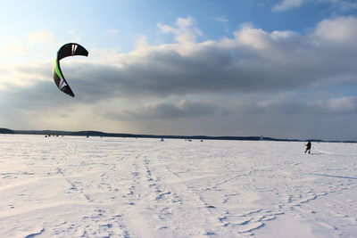 Person on kiteboarding on snow covered landscape