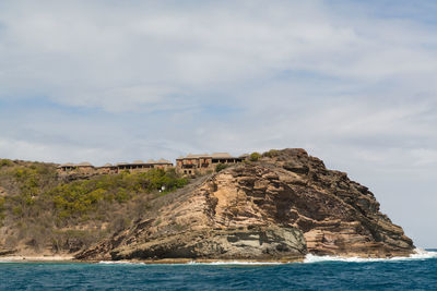 Rock formations by sea against sky