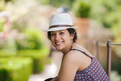 Portrait of smiling woman wearing hat outdoors