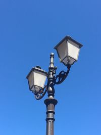 Low angle view of gas light against clear blue sky