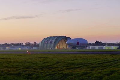 Built structure on landscape at sunset