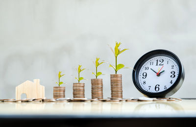 Close-up of clock on table against wall