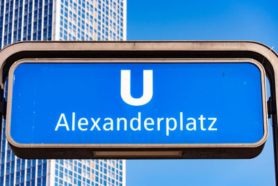 Low angle view of information sign against clear blue sky