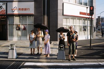 Group of people walking on road in city