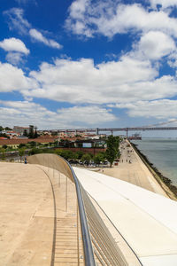 Railroad tracks by sea against sky in city