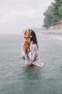 Full length of woman in sea against sky