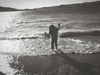 Rear view of playful girl standing on shore