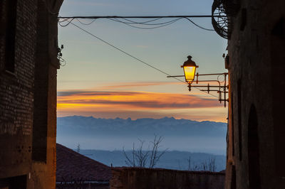 Low angle view of illuminated buildings against sky during sunset