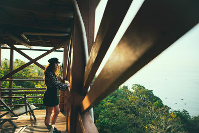 Side view of woman standing on bridge