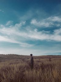 Man standing on field against sky