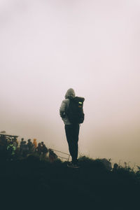 Man photographing on camera against sky